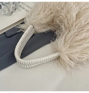 Gemütliche lockige Fleece-Handtasche Detail mit gewebtem weißem Ledergriff für den Herbst.