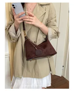 Brown suede shoulder bag for women, chic retro underarm bag with metal accents and charm.
