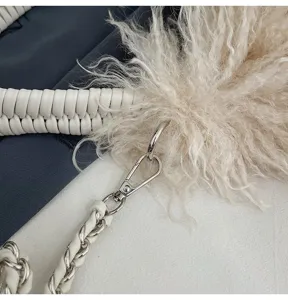 Nahaufnahme vom stilvollen Handtasche Leder geflochtenen Riemen, Kette und Pelzanhänger.