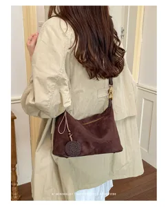 Stylish brown suede shoulder bag for women, trendy retro underarm bag with chic woven pendant.