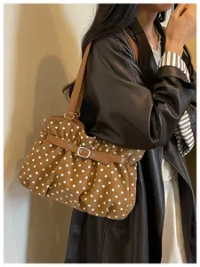 Vista detallada del bolso de hombro marrón con lunares fruncidos, diseño de moda elegante.