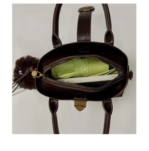 Sac à main femme en cuir marron foncé vue de dessus montrant la capacité intérieure.