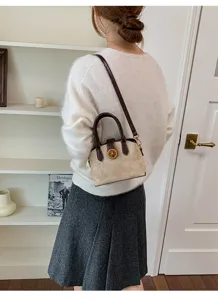 Vue détaillée d'un sac à bandoulière rétro pour femme en beige et marron avec fermoir.