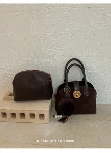 Élégant ensemble sac à main et pochette marron foncé avec fermoir tourniquet et charm en fourrure.