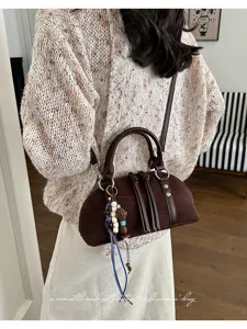 Gedetailleerd overzicht van een retro bruine dames handtas van suède met kralen.
