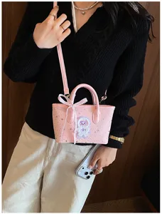 Pink PU leather shoulder bag detail, featuring star patterns, cute bow, and plush bear charm.