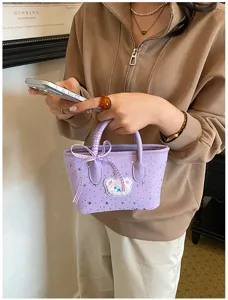 Detailed view of the stylish purple mini tote bag with cute bear patch, star pattern and ribbon.