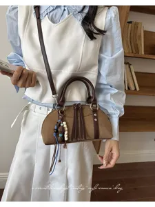 Detail van vintage bruine suède schoudertas, dagelijkse crossbody tas met kwastjes.