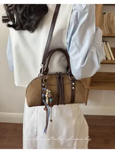 Vintage bruine suède handtas voor dames, elegante schoudertas met kwastjes en kralen.