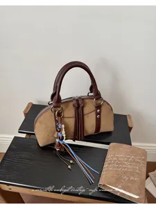 Vintage bruine suède handtas voor dames, chique handtas met handvat en stijlvolle kwastveder.