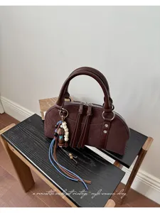 Retro bruine suade handtas met handgrepen en kwastjes, vintage schoudertas.