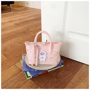 Close-up detail of pink tote bag featuring cute star patterns, stylish plaid bow and cute patch.