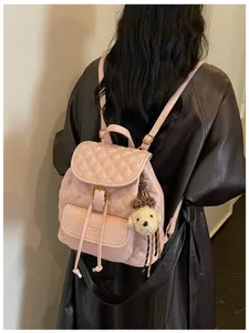 Stylish pink quilted casual vintage backpack for women, commuter travel bookbag with cute charm.