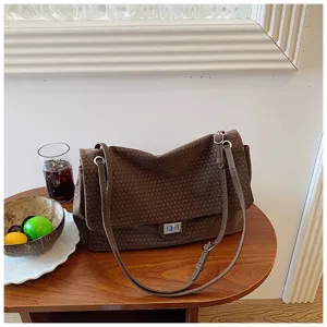 Borsa a tracolla in pelle intrecciata marrone, dettaglio vintage con chiusura in metallo.