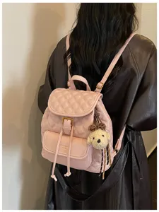 Pink quilted leather backpack for women, stylish travel daypack with cute puppy pendant.