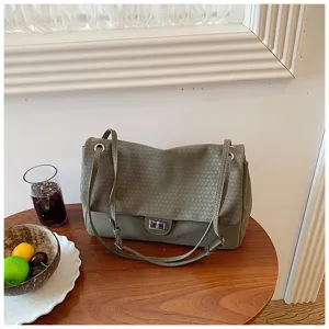 Vista dettagliata della borsa a spalla in pelle intrecciata grigio-verde con chiusura in metallo.