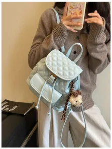 Light blue quilted casual backpack for women, stylish commuter travel daypack with bear pendant.