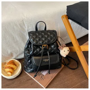Detailed view of black quilted leather backpack with front pocket and drawstring closure design.