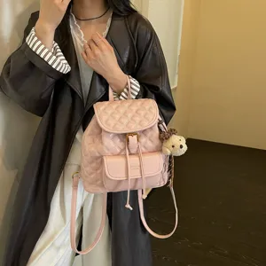 Stylish pink quilted leather backpack for women, cute casual travel school bag with bear charm.