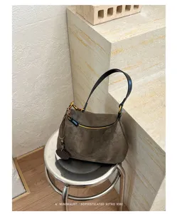 Retro suede shoulder bag for women, minimalist hobo design with zipper and chic strap.