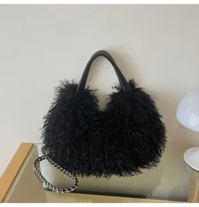Nahaufnahme der schwarzen flauschigen Handtasche mit geflochtenem Griff und Kette.