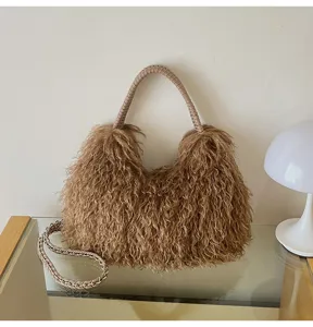 Nahaufnahme der braunen flauschigen Locken-Hobo-Tasche mit geflochtenem Griff am Tisch.
