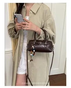 Chic brown leather pillow handbag with beaded charm, trendy vintage cross-body bag for women.