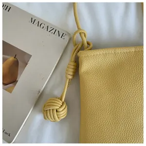 Mini borsa a tracolla in pelle gialla con un design di cinturino annodato chic ed elegante.