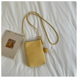 Vista dettagliata di una borsa a tracolla gialla alla moda per telefono con nodo e cinturino.