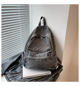 Detailopname van de vintage gewassen denim rugzak met voorvak en stevige ritssluitingen voor dagelijks.