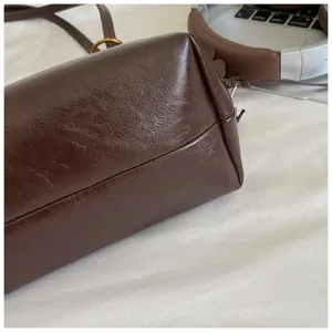 Detalle bolso de hombro de cuero marron, primer plano bolso bajo brazo vintage textura lisa.