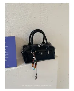 Chic black leather pillow bag with bead charm and zipper closure for women commute.