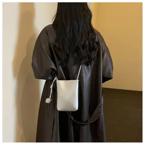 Primo piano di una mini borsa a tracolla argentata minimalista con elegante nodo.