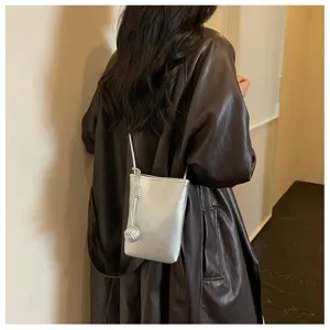 Dettaglio mini borsa a tracolla argentata in pelle testurizzata con decoro a nodo fine.