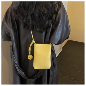 Vista dettagliata della mini borsa a tracolla gialla per telefono con cinturino annodato e chic.