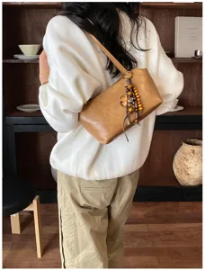 Bolso de hombro marrón elegante con colgante de cuentas, bolso minimalista para uso diario.