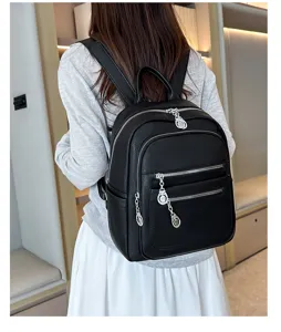 Detail view of women black leather backpack with multiple zipper pockets for daily commute use