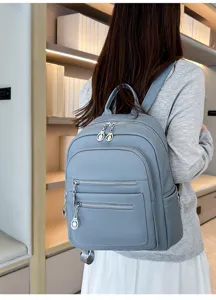 Casual women's large capacity backpack with multiple zipper pockets and light blue leather.