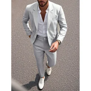 Completo da uomo grigio chiaro slim fit con camicia bianca per matrimoni ed affari.