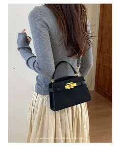 Detail view of the elegant retro black handbag with gold hardware and structured design.