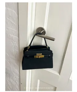 Chic black mini handbag with retro gold metal lock design, perfect for daily commuting and style.