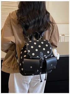 Detail shot of the stylish polka dot backpack highlighting its leather pockets and back design.