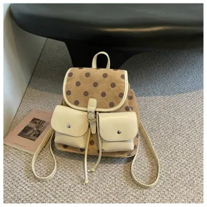 Detail shot of the Korean style polka dot backpack with cream front pockets and straps on carpet.