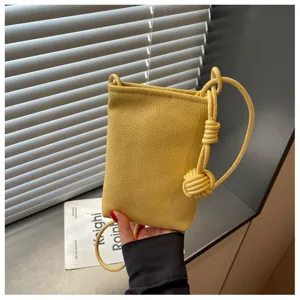 Vista dettagliata della mini borsa a tracolla per telefono in pelle gialla con nodo.