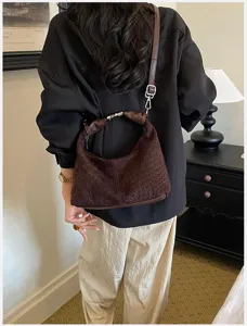 Vista detallada de un elegante bolso de hombro tejido marrón, estilo retro para mujeres.