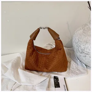 Vista detallada de un elegante bolso de mano marrón tejido para mujer, estilo de bolso de hombro.