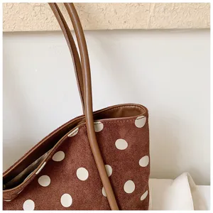 Vue détaillée du sac fourre-tout à pois marron, style vintage sac bandoulière.