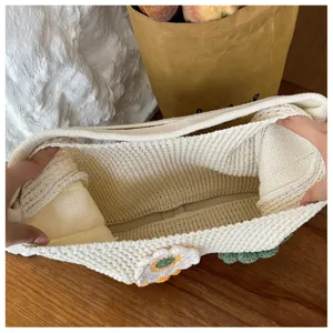 Detailed view of the hollow-out knit tote bag featuring a crochet flower and large capacity.
