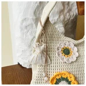Detail view of a knitted crochet floral tote bag, showing delicate handmade texture and charm.