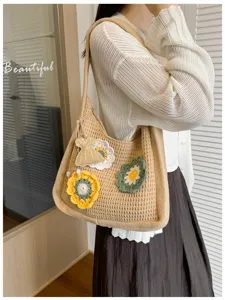 Detailed shot of knitted shoulder bag with floral crochet motifs and charm in summer style.